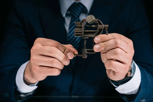 Cropped shot of businessman holding iron vise tool with russian ruble coin — Stock Photo