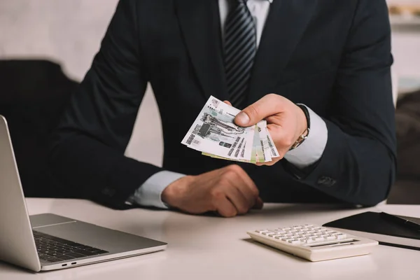 Обрізаний знімок бізнесмена, який тримає російські рублі банкноти на робочому місці — стокове фото