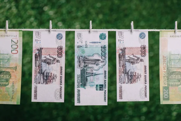 Billetes de rublos colgados con pinzas de ropa en el tendedero, concepto de lavado de dinero - foto de stock