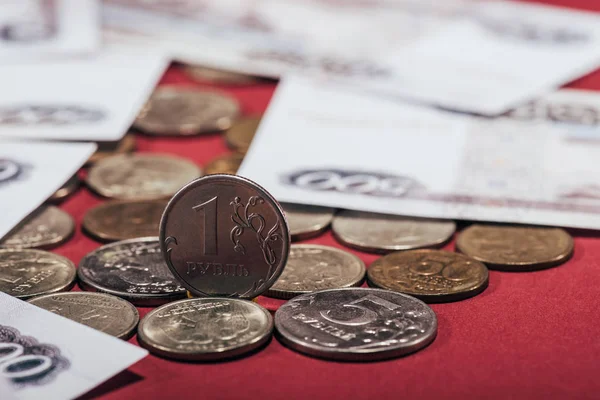 Nahaufnahme russischer Rubel-Münzen und -Banknoten auf rotem, selektivem Fokus — Stockfoto