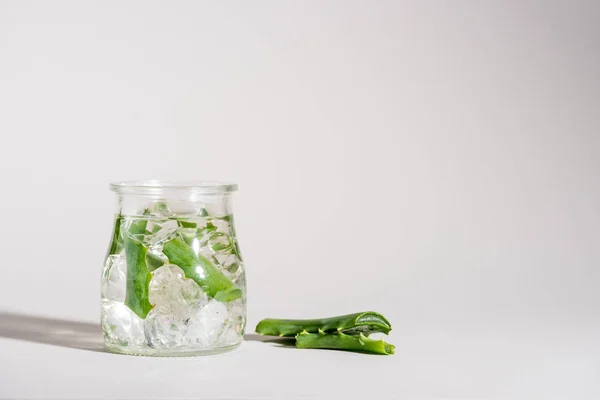 Studio shot di vaso di vetro contenente foglie di aloe vera e ghiaccio — Foto stock