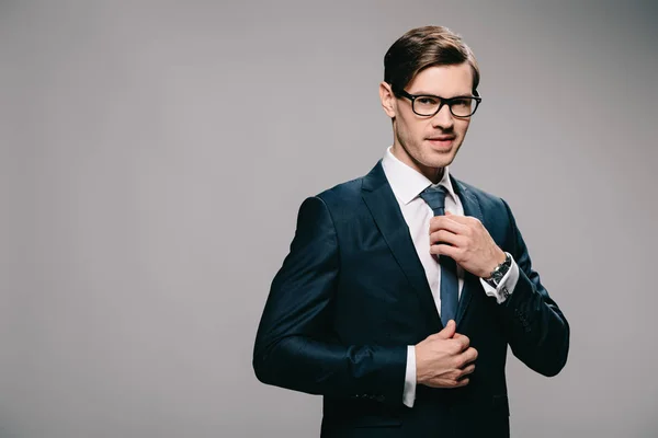 Schöner Mann im Anzug mit Krawatte auf grauem Hintergrund — Stockfoto