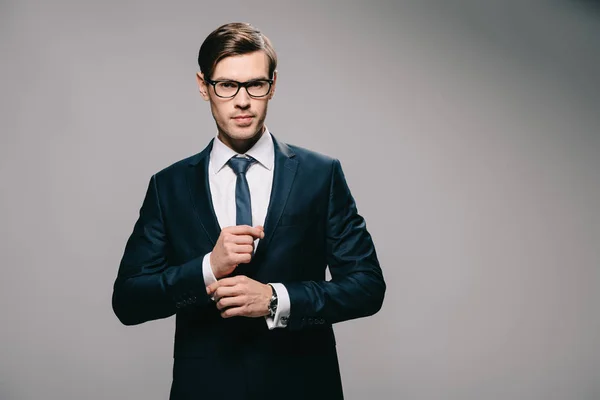 Красивий бізнесмен стоїть в костюмі на сірому фоні — стокове фото