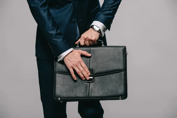 Vista ritagliata di uomo d'affari apertura valigetta isolata su grigio — Foto stock