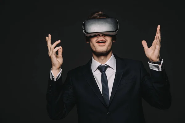 Excited businessman in virtual reality headset isolated on black — Stock Photo