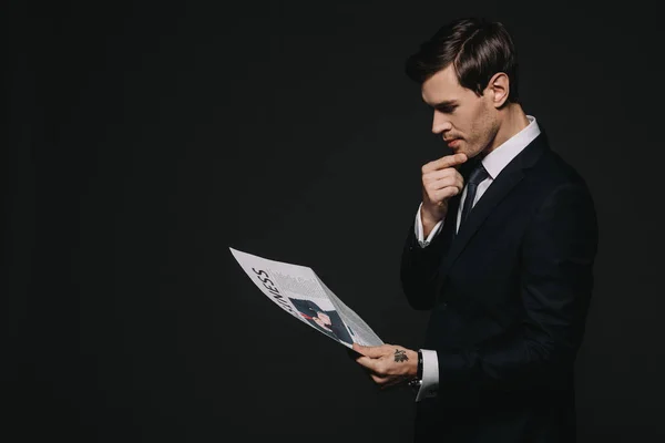 Впевнений бізнесмен читає бізнес-газету ізольовано на чорному — стокове фото