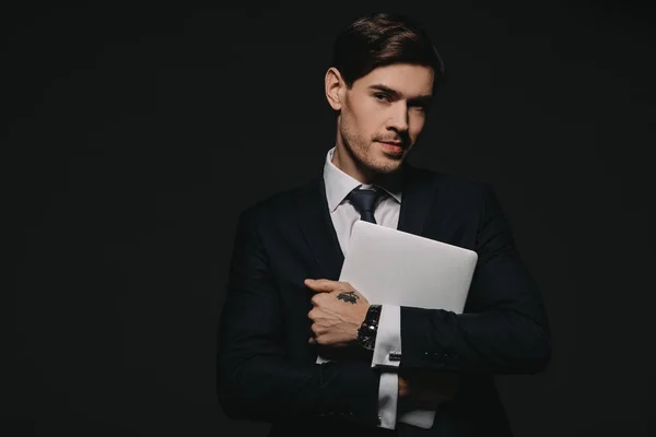 Hombre de negocios en ropa formal sosteniendo tableta digital en manos aisladas en negro - foto de stock