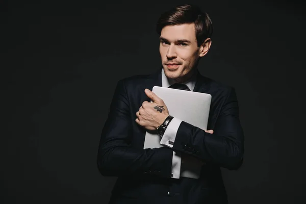 Handsome businessman in formal wear holding digital tablet isolated on black — Stock Photo