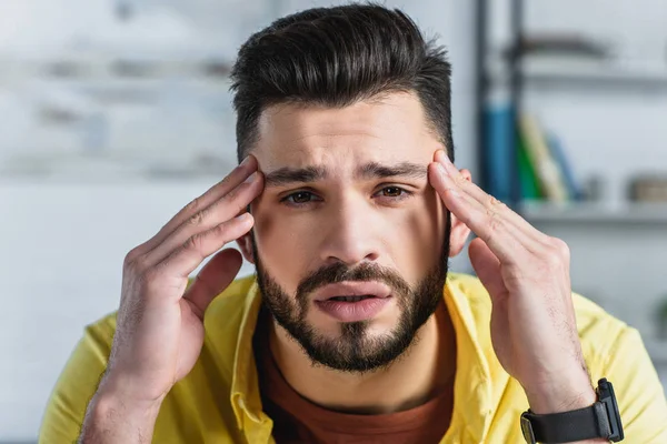 Close up de homem de negócios barbudo tocando a cabeça no local de trabalho — Fotografia de Stock