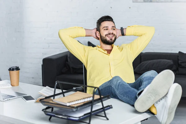 Smiling bearded businessman with crossed arms looking away at office — Stock Photo