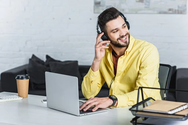 Усміхнений бородатий бізнесмен слухає музику і дивиться геть — стокове фото