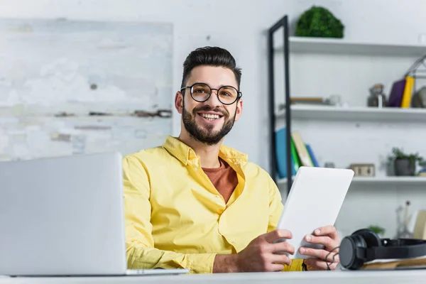 Cheerful businessman in glasses looking at camera at office — Stock Photo