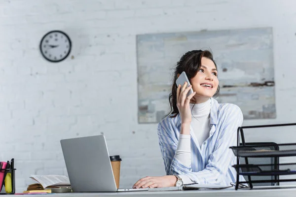 Beautiful businesswoman talking on smartphone and  looking away at office — Stock Photo