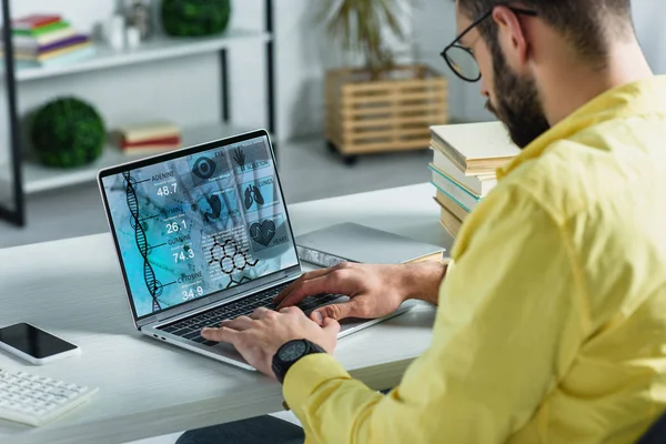 Bärtiger Mann schaut auf Laptop mit medizinischer Website auf dem Bildschirm in modernem Büro — Stockfoto
