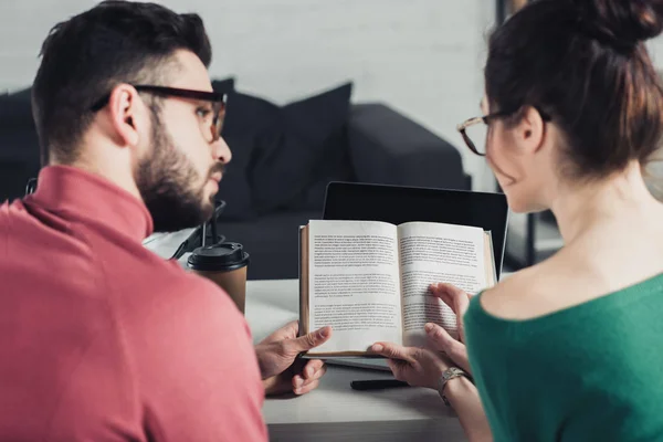 Selective focus of book in hands of coworkers in modern office — Stock Photo