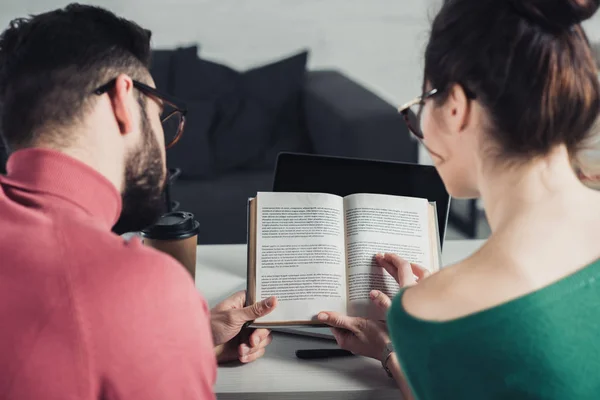 Selective focus of book in hands of colleagues in modern office — Stock Photo