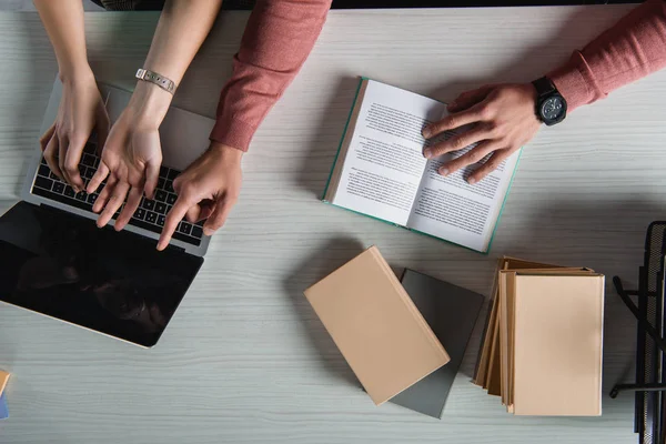 Ansicht von oben: Mann zeigt mit Finger auf Laptop mit leerem Bildschirm neben Frau — Stockfoto