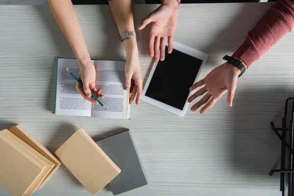 Vista superior de la mujer sosteniendo lápiz cerca de hombre gesto cerca de tableta digital con pantalla en blanco - foto de stock