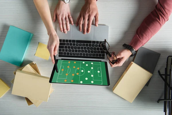 Vista ritagliata della donna che punta al computer portatile con gioco sullo schermo vicino all'uomo che tiene gli occhiali — Foto stock