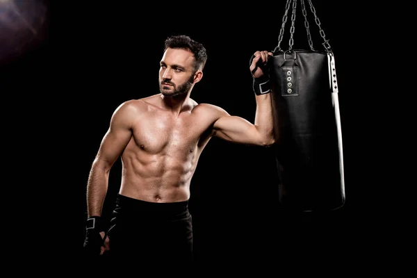 Boxer shortless em pé perto de saco de boxe isolado em preto — Fotografia de Stock