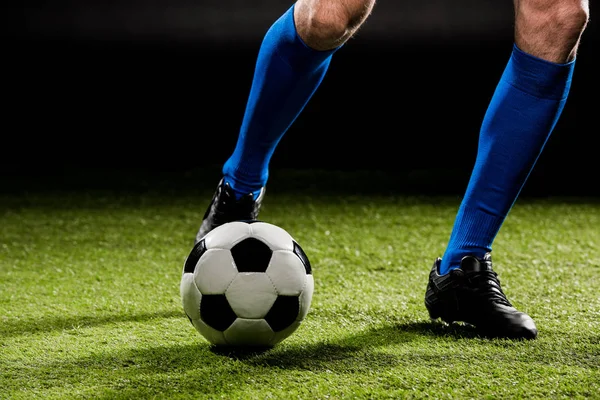 Vista cortada de desportista jogando com bola na grama verde isolado em preto — Fotografia de Stock