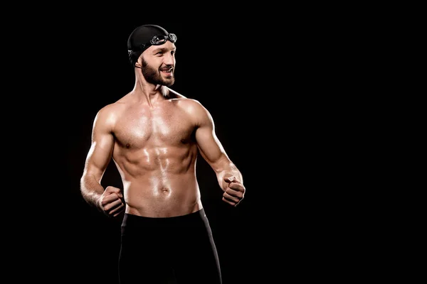 Nadador alegre de pie en gorra de natación y gafas de natación aisladas en negro - foto de stock