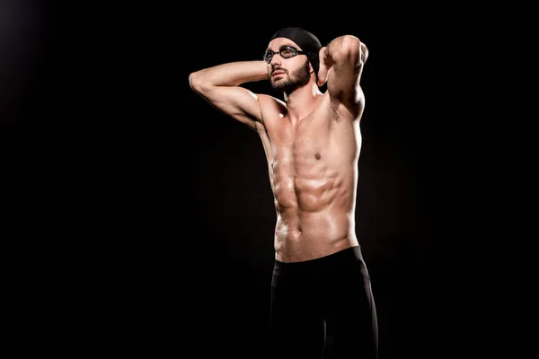 Nadador confiado de pie en gorra de natación y posando aislado en negro - foto de stock