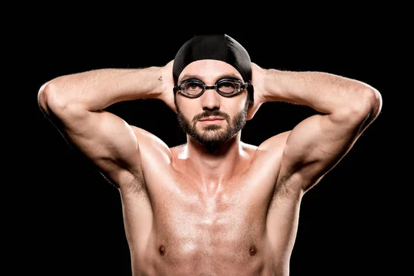 Guapo nadador posando en gorra de natación y gafas aisladas en negro - foto de stock