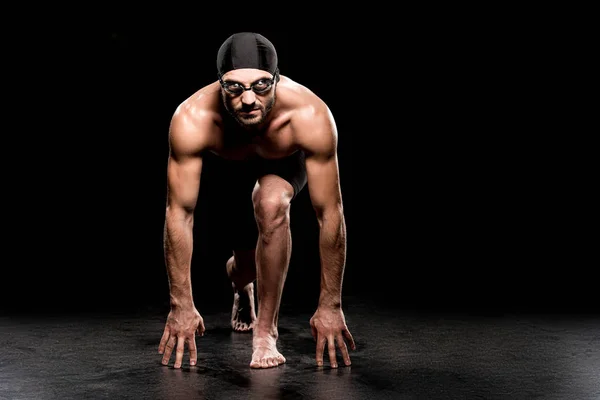 Schöne Schwimmerin steht in Startposition auf schwarzem Hintergrund — Stockfoto