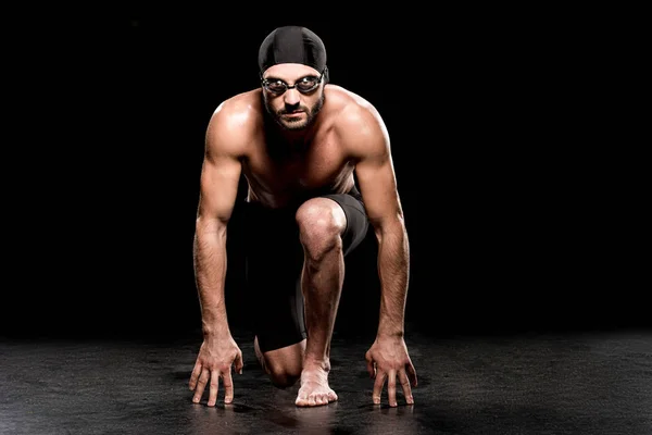 Athletic swimmer standing in start position on black background — Stock Photo