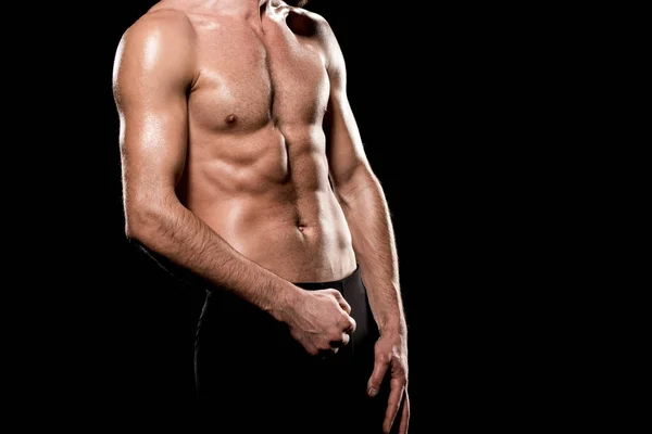 Обрезанный вид мускулистого спортсмена, стоящего изолированно на черном — стоковое фото
