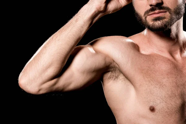 Cropped view of strong sportsman showing muscles isolated on black — Stock Photo