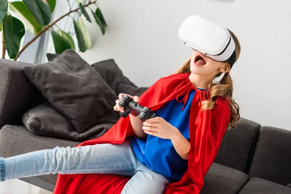 Cute kid in virtual reality headset playing video game — Stock Photo