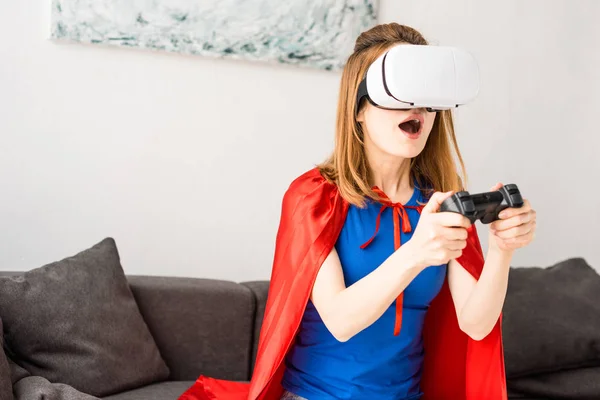 Hermosa madre en auriculares de realidad virtual jugando videojuego - foto de stock
