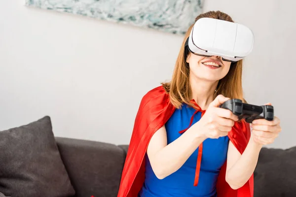 Mère en manteau rouge et casque de réalité virtuelle jouant au jeu vidéo — Photo de stock
