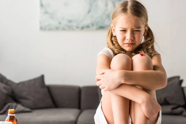 Расстроенный ребенок с раной плачет дома — стоковое фото
