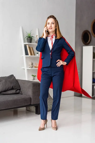 Femme d'affaires en costume bleu et cape rouge parlant sur smartphone — Photo de stock