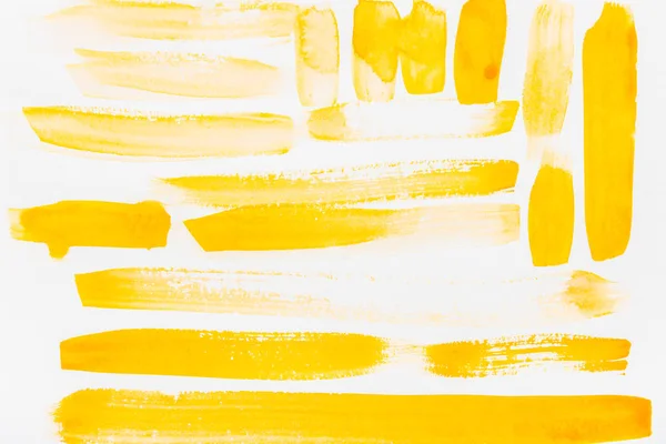 Top view of yellow brushstrokes on white background — Stock Photo