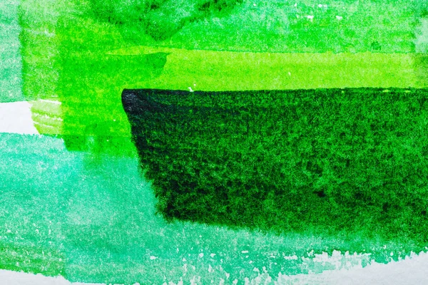 Draufsicht auf grüne Aquarell-Pinselstriche auf weißem Papier — Stockfoto