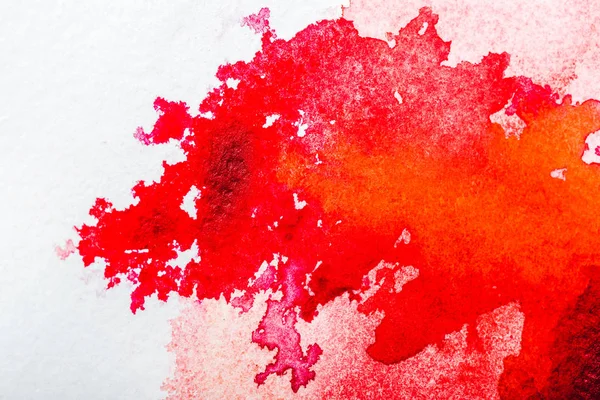 Vista superior do derramamento de aquarela vermelha no papel branco — Fotografia de Stock