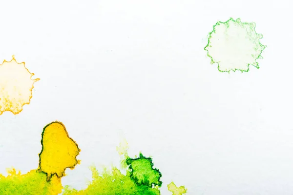 Top view of yellow and green watercolor spills on white background — Stock Photo