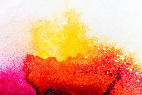 Top view of yellow, pink and red watercolor spills on white paper — Stock Photo