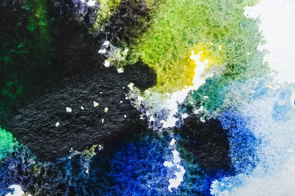 Вид зверху на синій, чорний і зелений акварельні розливи на білому тлі — стокове фото