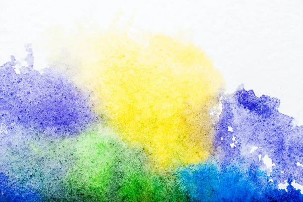Vista dall'alto di blu, giallo, viola e verde acquerello fuoriuscite su sfondo bianco — Foto stock