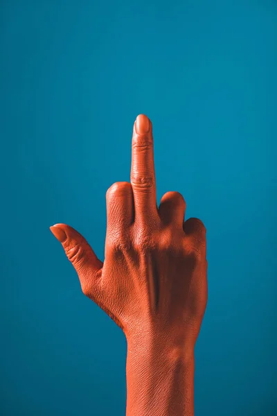 Vista recortada de la mujer que muestra el dedo medio en la mano de color coral sobre fondo azul, el color del concepto 2019 — Stock Photo