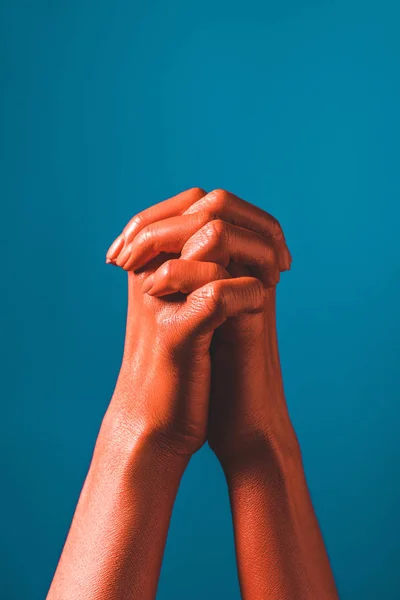 Обрезанный вид женщины жестикулирующей коралловым цветом рук на синем фоне, цвет концепции 2019 года — стоковое фото
