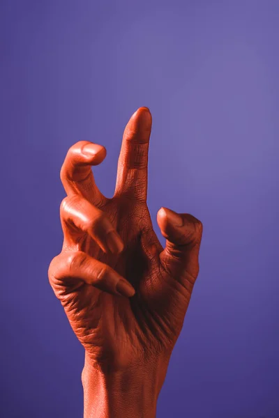 Vue recadrée de la femme gestuelle avec la main de couleur corail sur fond violet, couleur du concept 2019 — Photo de stock