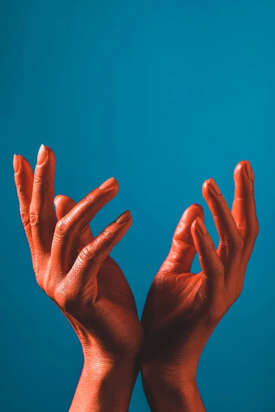 Teilansicht einer gestikulierenden Frau mit korallenfarbenen Händen auf blauem Hintergrund, Farbe des Konzepts 2019 — Stockfoto