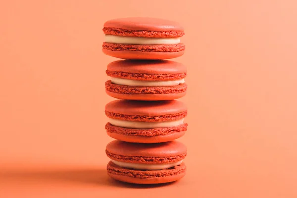 Stack of coral macarons on coral background, color of 2019 concept — Stock Photo