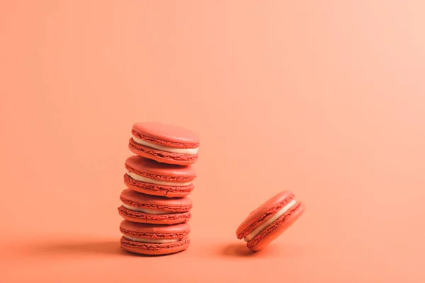 Tasty coral macarons on coral background, color of 2019 concept — Stock Photo
